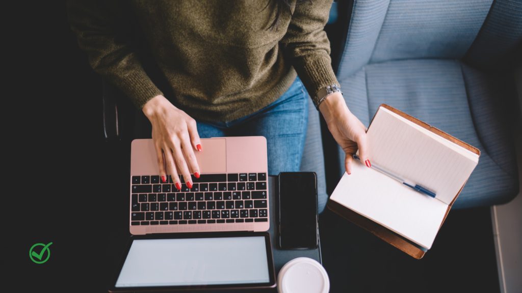 une femme d'affaire avec un petit pc portable 14" sur les genoux. Elle est dans les transports en communs